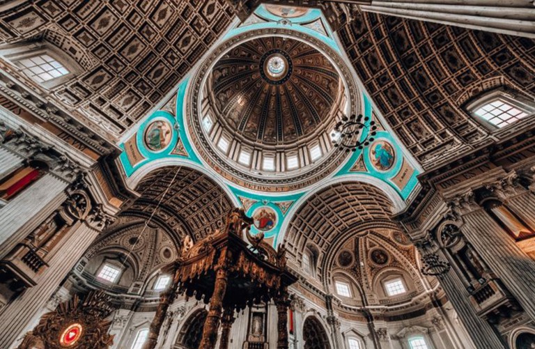 Interieur van De Basiliek van de Heiligen Agatha en Barbara met een beschilderde koepel, hoge zuilen en gedetailleerde architectuur. (vergroot foto)