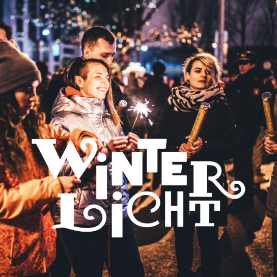 Mensen vieren een winterevenement met lichtjes in de avond, met de tekst "Winterlicht" op de voorgrond. (vergroot foto)